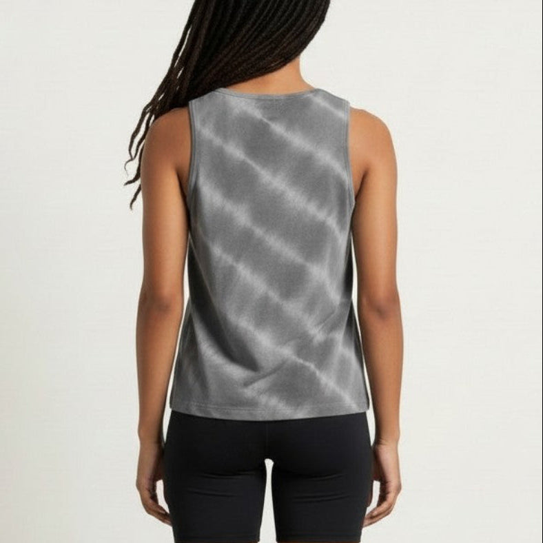 Person wearing a gray sleeveless top and black shorts on a plain background