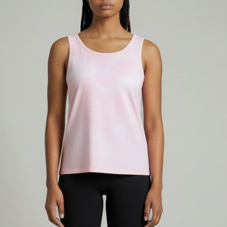 Woman wearing a pink tank top and black shorts against a plain background